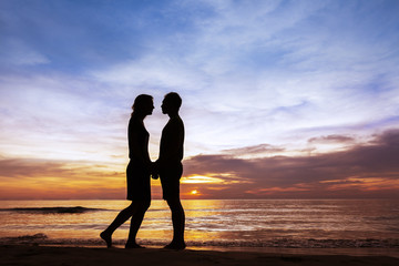 Couple kissing on the beach at sunset