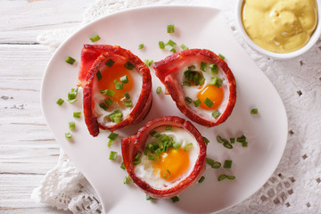 Fried eggs wrapped in bacon close-up and sauce. Horizontal top view
