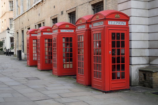Traditional British red telephone boxes in a row