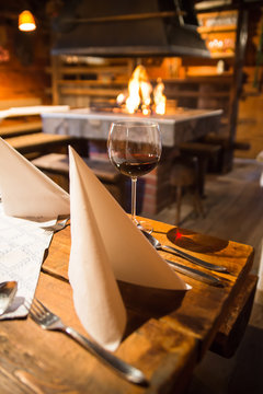 Besteck auf einem rustikalem Tisch in einer Hütte bei einer offenen Feuerstelle