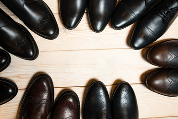many leather men's shoes on wooden background