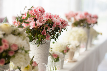 Obraz na płótnie Canvas flowers in a row on a table in a cafe