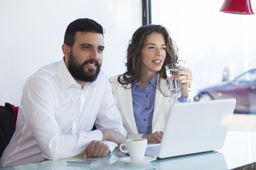 Smiling attractive businesswoman and man having discussion. While drinking coffee at lunch break. Businessman And Businesswoman Meeting In Coffee Shop. Shallow depth of field