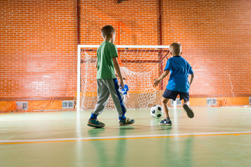 Two young boys playing soccer together