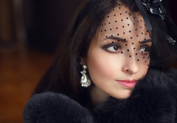 Elegant brunette retro woman wearing little hat with veil and lu