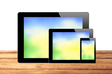 Touch Screen Tablets with bright screen on wooden table isolated