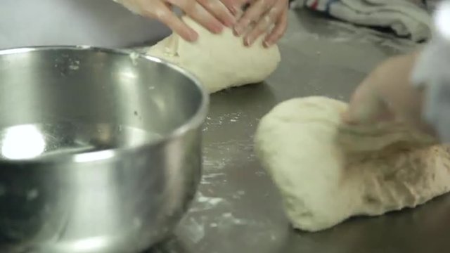 Woman's hands knead the dough
