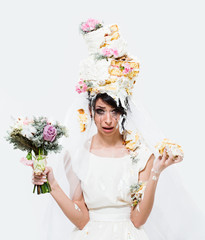 Unhappy crying bride with wedding cake on her head