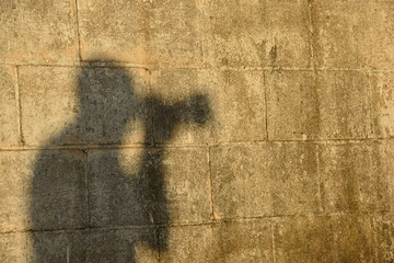 male photographer silhouette on grungy block wall