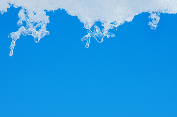 Background with transparent icicles on  background of blue sky