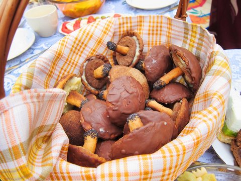 Mushrooms chocolate candy holiday snacks cookies festive food in a basket on a table picnic feast outdoors