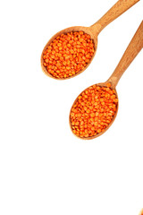 Red lentils in the wooden spoons on a white background