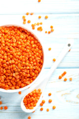 Red lentils in bowl on a blue wooden table