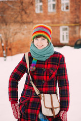 Girl in red checkered coat standing at old town background
