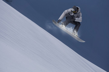 Flying snowboarder on mountains. Extreme sport.