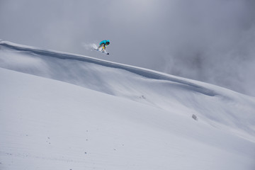 Flying snowboarder on mountains