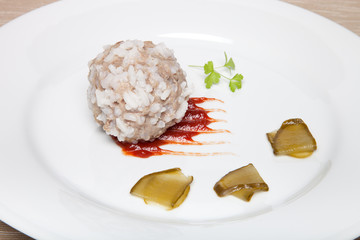 Cutlet with rice, slices of pickle and ketchup on white plate on