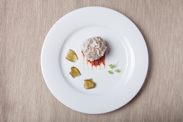 Cutlet with rice, slices of pickle and ketchup on white plate on