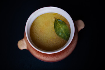 Rice soup in a clay pot on a black table or background. Toned
