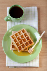 Traditional belgium soft fresh waffles with a honey