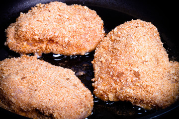Chicken cordon bleu fried in oil in a frying pan. Selective focu