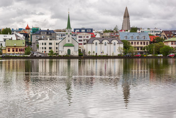 Fototapeta na wymiar Buildings reflecting in lake Tjornin in the city of Reykjavik, Iceland.