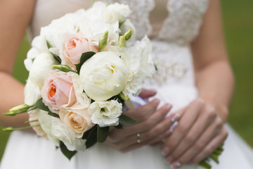 Obraz na płótnie Canvas Невеста держит букет из роз и пионов