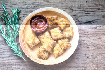 Plate with fried ravioli on the wooden board