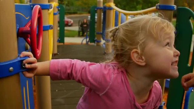 Cute little girl smiles at her friend on the playground 