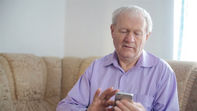 The old man uses a smartphone
