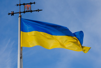 The blue-yellow Ukrainian flag with the emblem of Lviv on the flagpole. A horizontal view