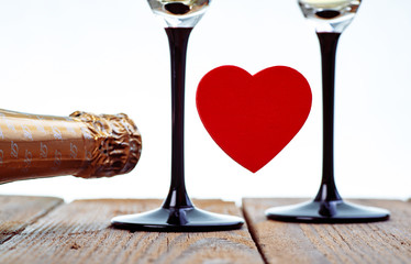 Holidays Decoration With Red Heart, Two Glasses And Bottle Of Champagne On Old Boards With White Background.