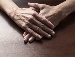 Fototapeta premium talking hands concept - female flat hands crossed and joined together to relax or meditate on wooden table,studio shot