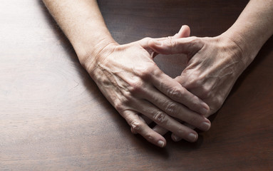 Fototapeta premium talking hands concept - female hands touching together for confusion or embarrassment on wooden table,studio shot