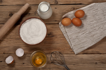 Flour, brown eggs, rolling pin, milk and whisk