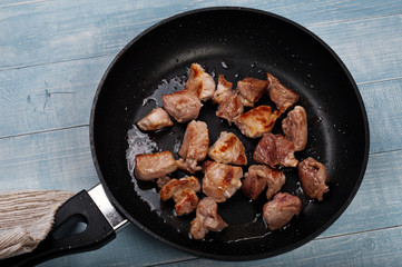 Fried meat in a frying pan closeup