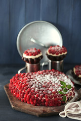 Sweet cake with raspberries on color wooden background