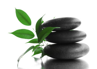 Fototapeta na wymiar Stack of stones and a green flower, isolated on white. Spa relaxation concept