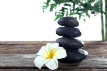 Fototapeta na wymiar Spa stones, a candle and a lotus, isolated on white