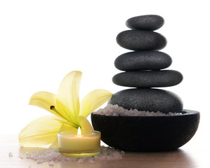 Fototapeta na wymiar Spa stones with lily, candle and sea salt, isolated on white