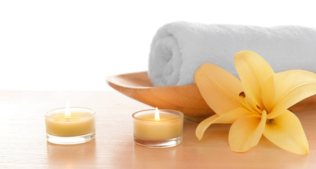 Fototapeta na wymiar Spa towel with candles and lily, isolated on white