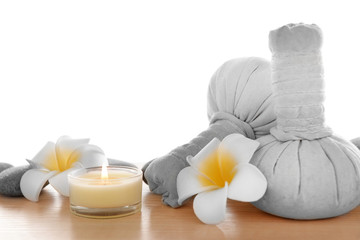 Fototapeta na wymiar Massage bags with plumeria and candle, isolated on white