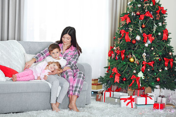 Obraz na płótnie Canvas Mother with daughter and son near Christmas tree