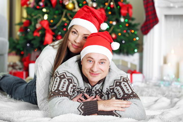 Happy Family lying on carpet, on Christmas tree background