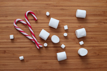 marshmallow and sweet canes on wooden surface