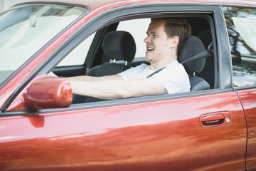 Wütender junger Mann sitzt im Auto