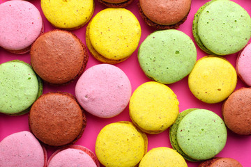 Fototapeta na wymiar Sweet and colorful french macaroons on pink background