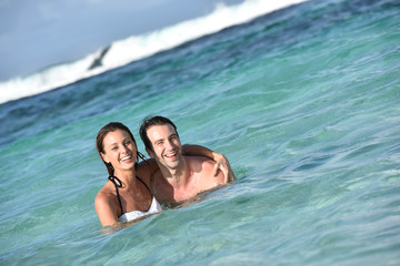 Cheerful couple enjoying sea bath in Caribbean island