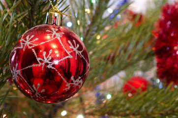 red glass Christmas Toy on a background of the decorated Christmas tree