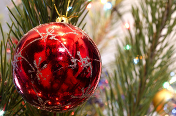 red glass Christmas Toy on a background of the decorated Christmas tree